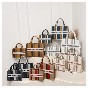 Eleganti borse tote in tela a righe di varie dimensioni con manici superiori e logo