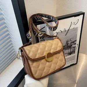 Chic beige quilted crossbody bag with brown trim and stylish wide jacquard strap