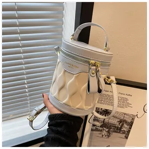 Detail of color-block bucket bag showing wavy texture and golden hardware accents