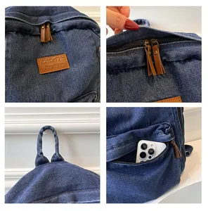Detail of denim backpack showing leather logo tag, side zipper pocket, and brown pull tabs
