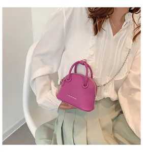 Dettaglio mini borsa a conchiglia viola con trama a grana e tracolla a catena