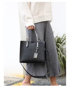 Detail of crocodile pattern leather bag with snake print handle and metallic buckle
