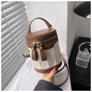 Detail of cylinder bucket bag featuring wave pleated texture and gold zippers