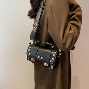 Retro black leather crossbody bag with gold studs and ethnic style patterned wide strap