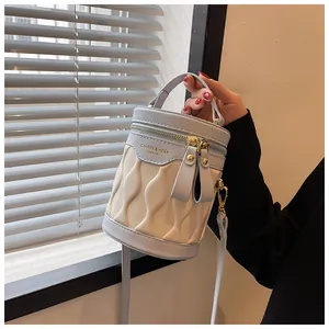 Detail of blue and white bucket bag with wave quilted texture and dual zippers