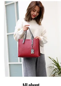 Detail of red crocodile texture tote with black and white snakeskin handles and hardware