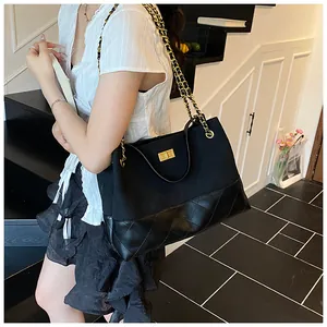 Borsa tote trapuntata classica con tracolla a catena dorata mostrata in città
