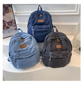 Three colors of washed denim backpacks in light blue, dark blue, and charcoal grey tones
