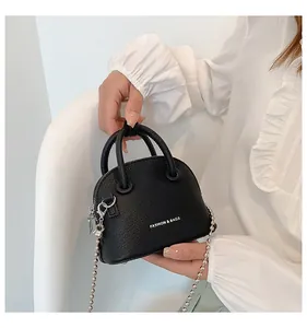 Dettaglio mini borsa a conchiglia nera texture litchi con catena a sfere d'argento