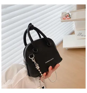 Dettaglio mini borsa a conchiglia motivo litchi con catena argento e manico corto