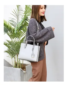 Detail of grey crocodile texture tote bag with snake pattern handles and red edge oil