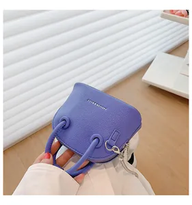 Dettaglio della mini borsa viola in pelle con texture litchi e catena in metallo