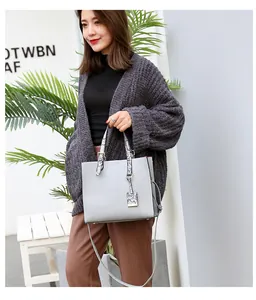 Detailed texture of grey crocodile pattern tote bag with snakeskin printed handles