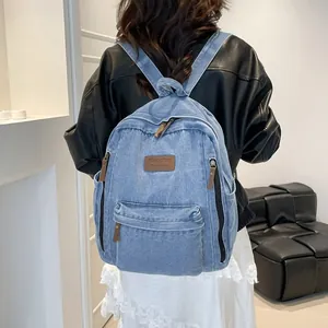 Large denim backpack with leather details shown on a model for a casual travel style