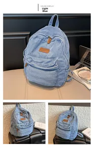Detail view of light blue denim backpack with premium brown leather decorative accents