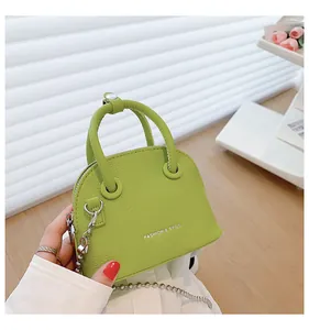 Dettaglio mini borsa a conchiglia verde trama litchi con catena in argento e scritte