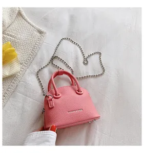 Dettaglio della mini borsa a conchiglia rosa con texture litchi e catena a sfere argento