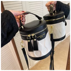 Detail of a black and white bucket bag with wave texture and gold hardware on mirror