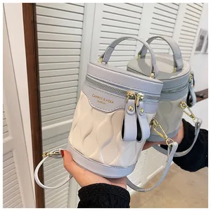 Detail view of two-tone bucket bag featuring 3D wave texture and gold zipper hardware
