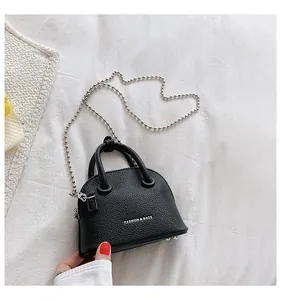 Dettaglio mini borsa a conchiglia nera in grana litchi con catena a sfere d'argento