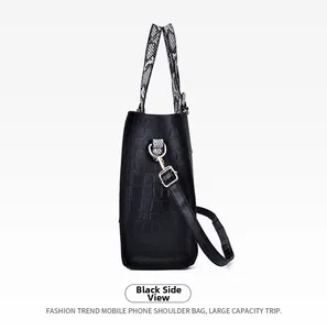 Detail of black faux crocodile leather tote with snake print handle and gold hardware