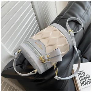 Close-up of contrast color bucket bag featuring quilted diamond pattern and gold hardware