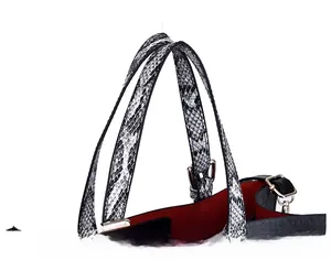 Detail of snake pattern tote handle with contrasting red lining and metallic hardware