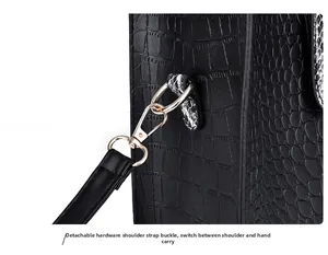Detail of gold metal hook and black-white snake skin trim on crocodile tote bag
