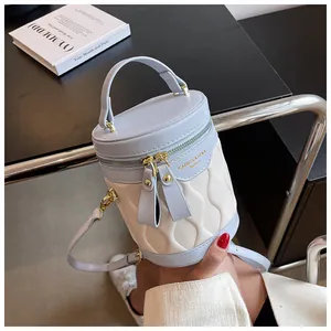Detail of blue and cream bucket bag showing wave quilting and gold zipper closure