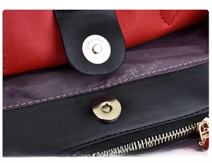 Detail of magnetic snap closure and red interior lining on a bicolor tote bag