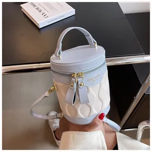 Detail of blue and white bucket bag featuring wave quilting and golden hardware