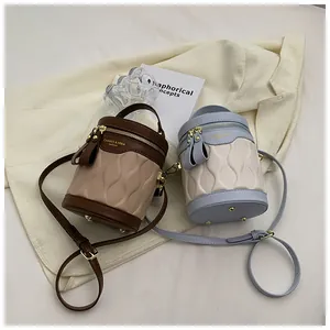 Detail view of stylish bucket bags with wave texture and metal zipper closure