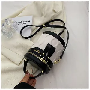 Detail of contrast bucket bag featuring wavy texture and gold zipper with leather strap