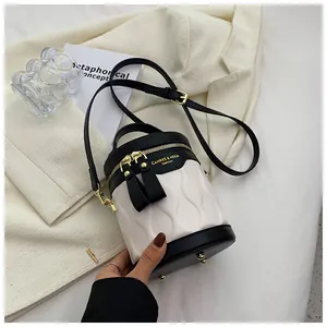 Detail of the black and white contrast bucket bag with wave texture and gold hardware