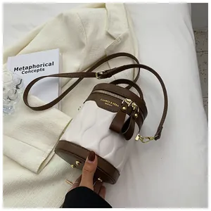 Detail of contrast bucket bag featuring wavy quilted leather and gold zipper hardware