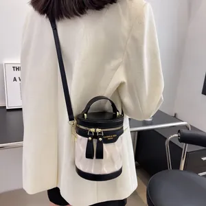 Contrast stitching bucket bag with pleated leather and black trim shown on model