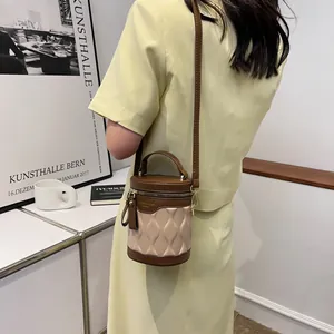 Minimalist cylinder bucket bag with contrast brown and pink leather and wavy texture