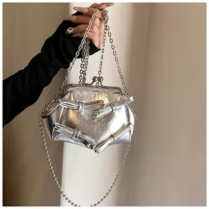 Dettaglio borsa metallizzata argento con fiocchi, chiusura retrò e tracolla a catena