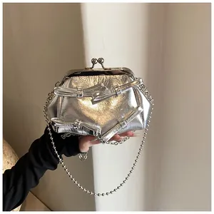 Dettaglio mini borsa argento metallizzato con fiocchi 3D, chiusura a scatto e catena