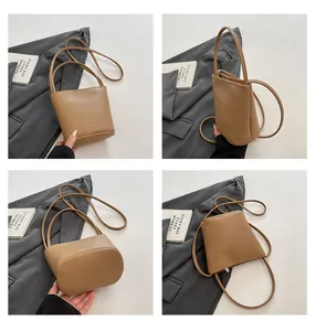 Detail view of khaki litchi grain bucket bag showing structure and texture from multiple angles