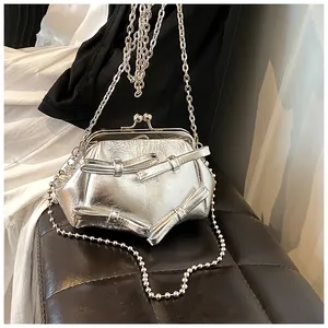 Dettaglio borsa argento con fiocchi, trama increspata e chiusura in metallo vintage