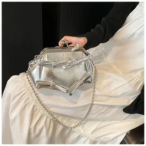 Borsa a mano argento metallizzato con fiocchi, chiusura vintage e tracolla a catena