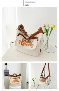 Dettaglio della grande borsa tote in tela bianco crema con tasca a patta e manici marroni