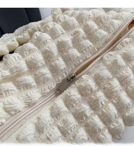 Détail de la fermeture éclair argentée sur tissu texturé popcorn blanc crème de sac