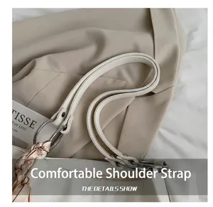 Detail showing white crocodile pattern texture with silk scarf and metal ring on shoulder bag