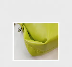 Dettaglio borsa in pelle verde lime con cuciture bianche a contrasto e hardware in argento