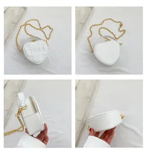 Viste multiple di una borsa bianca a cuore con catena e motivi a quadrifoglio