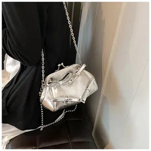 Dettaglio mini borsa a catena argento in pelle metallizzata con fiocchi e chiusura a scatto