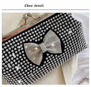 Detailed view of black party clutch featuring rhinestone bow and sparkling diamond accents