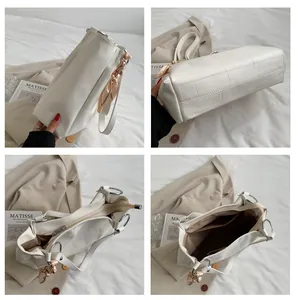 Detail view of white tote bag showing crocodile texture and spacious internal pockets